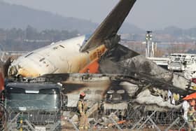 Firefighters check near the wreckage of a passenger plane at Muan International Airport 