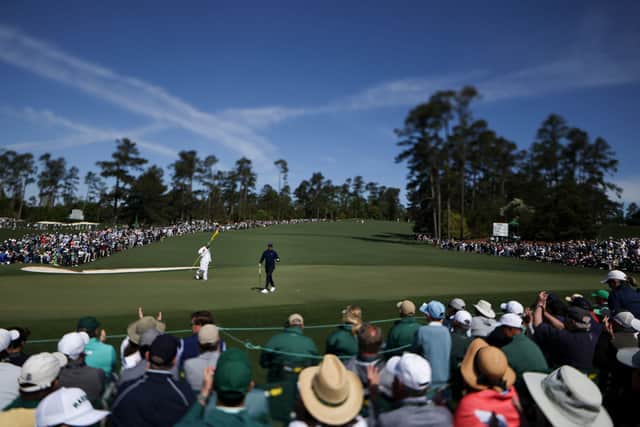 Patrons surround the second green at Augusta Natipnal as Rory McIlroy reads his putt