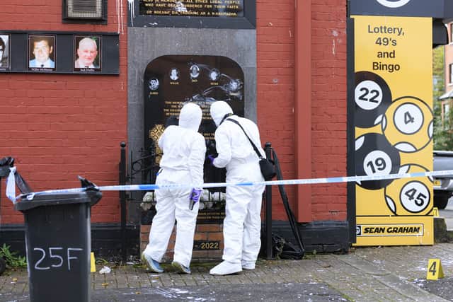 Police investigators at the plaque for victims of the Sean Graham Bookmakers attack after it vandalised in early September (Liam McBurney/PA)