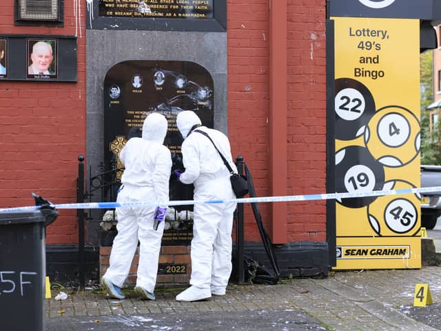 Police investigators at the plaque for victims of the Sean Graham Bookmakers attack after it vandalised in early September (Liam McBurney/PA)