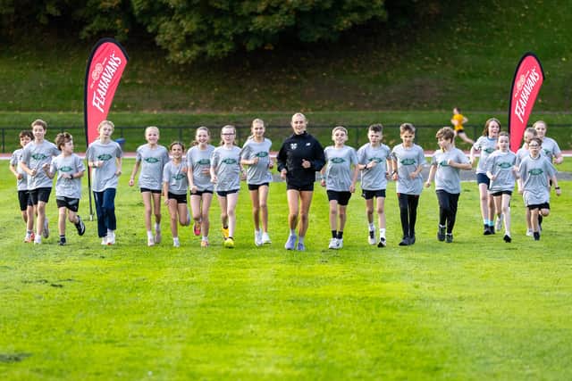 Members of the Flahavan's 2026-27 XC Squad with League Ambassador Kirsti Foster at the launch of the 20th Athletics NI XC League