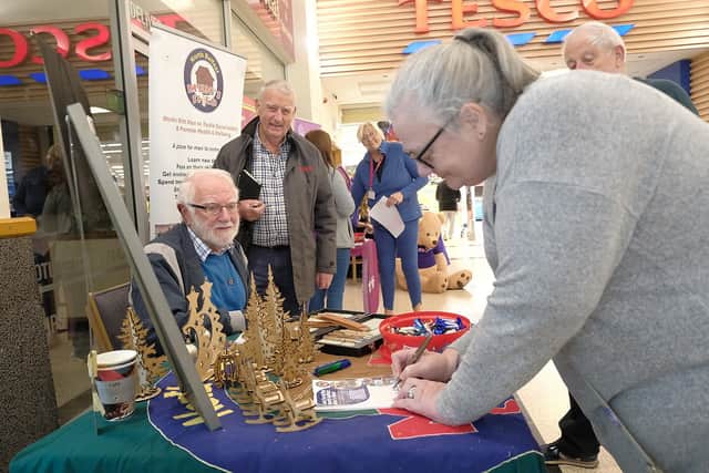 Alan Kinghan (North Belfast Men's Shed) talking to shoppers at the community event.