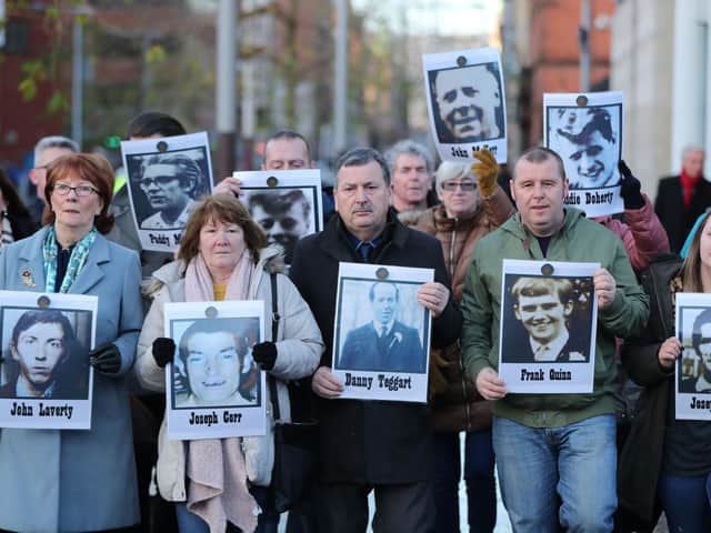 Family members outside Laganside Courts in Belfast hold images of some of those who were killed in disputed circumstances over the course of three days between August 9-August 11, 1971