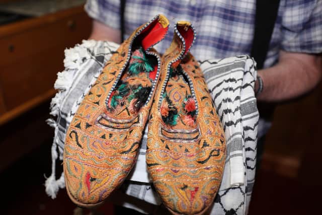 Kevin Carson, curator of Roddy McCorley Society living history museum in Belfast, holds a pair of Col Muammar Gaddafi's slippers. They were gifted to IRA commander Joe Cahill during talks which saw the provisionals given tonnes of arms and Semtex from Libya. The slippers are now a key exhibit in the project. Photo: Niall Carson/PA Wire