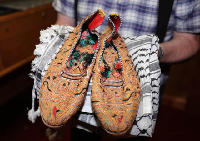 Kevin Carson curator of Roddy McCorley Society living history museum in Belfast holds a pair of Col Muammar Gaddafi's slippers. Photo: Niall Carson/PA Wire