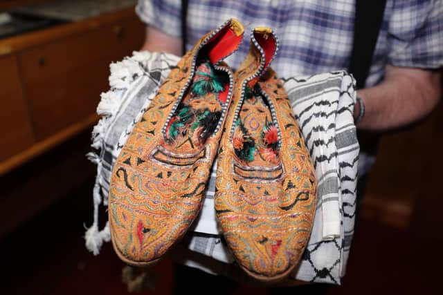 Kevin Carson curator of Roddy McCorley Society living history museum in Belfast holds a pair of Col Muammar Gaddafis slippers. PA Photo. Picture date: Tuesday December 31, 2019. See PA story ULSTER Museum. Photo credit should read: Niall Carson/PA Wire