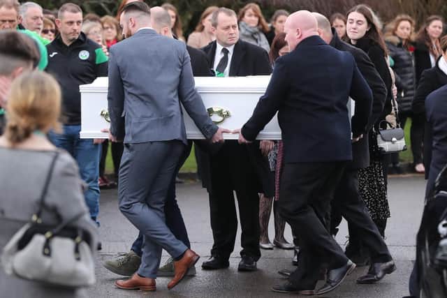 Andrew McGinley (centre) watches as a coffin of one of his three children, Conor, nine, Darragh, seven and Carla,  three, who were found dead in their home at Parson's Court in Newcastle, in the south-west of Dublin city on Friday, is carried into the Church of the Holy Family in Rathcoole, Dublin