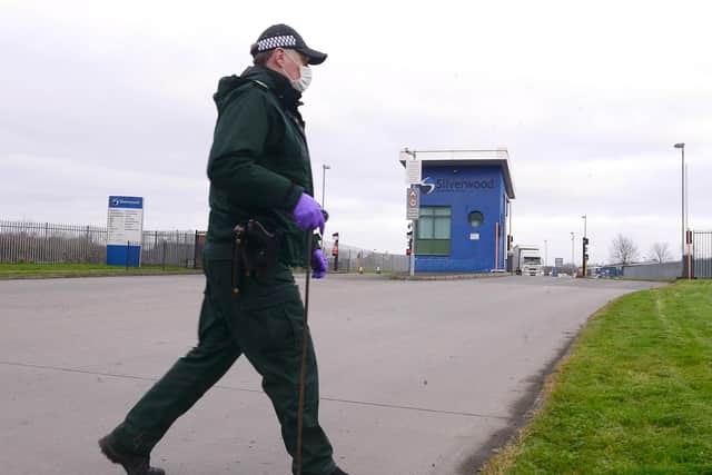 A PSNI officer pictured at the location where the explosive device was discovered attached to a lorry. (Photo: Pacemaker)