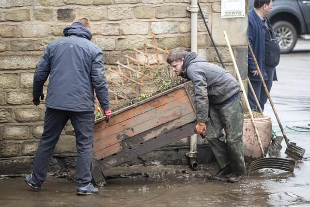 People clear up following Storm Ciara in Mytholmroyd in the Upper Calder Valley in West Yorkshire, as Storm Dennis is expected to hit over the weekend