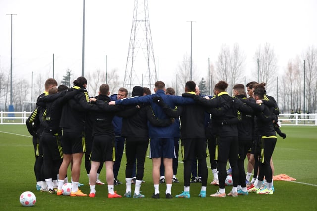Leeds United squad gather in a huddle.