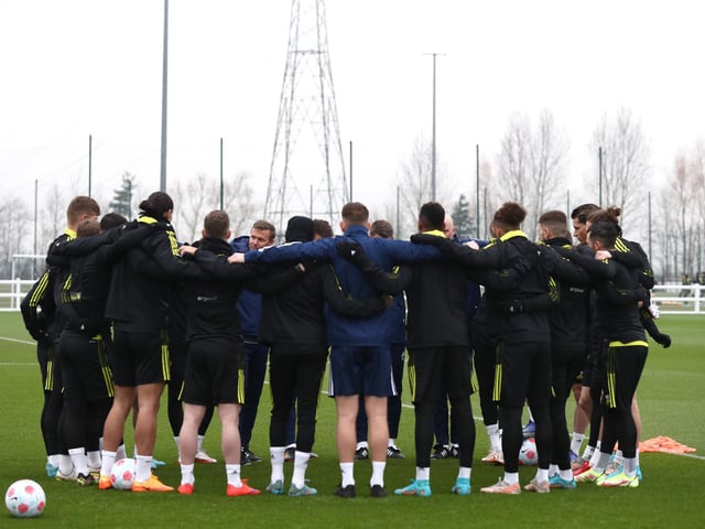 Leeds United squad gather in a huddle.