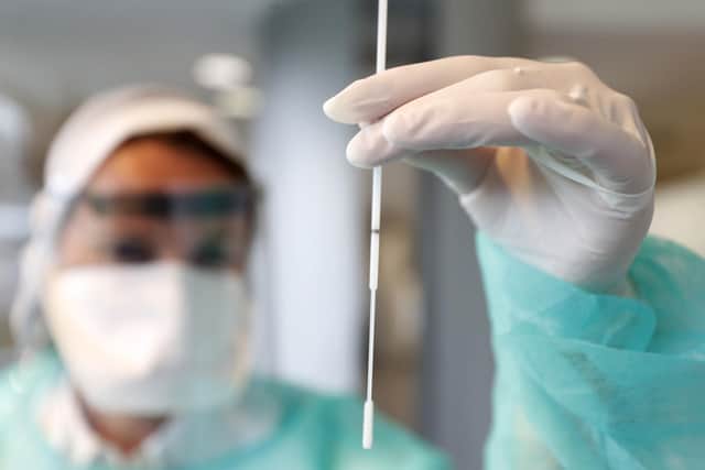 A technician shows a nasal swab during a rehearsal of a COVID-19 testing