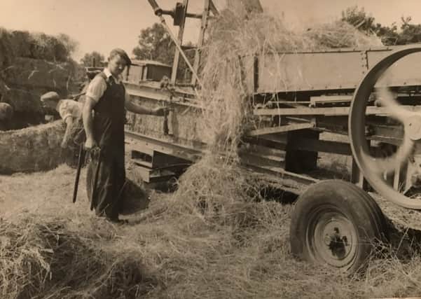 Edwin McFadden explains: “This photograph shows my uncle John working with an old time big square baler. The straw fell from the thrasher into the baler. John also worked at a neighbouring farm of the Marshall's thrashing corn and would work at various farms in the district.”