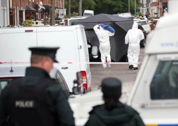 PSNI and forensic officers at the scene where a man was shot dead in Rodney Parade in the Lower Falls area of Belfast on Saturday PICTURE BY STEPHEN DAVISON