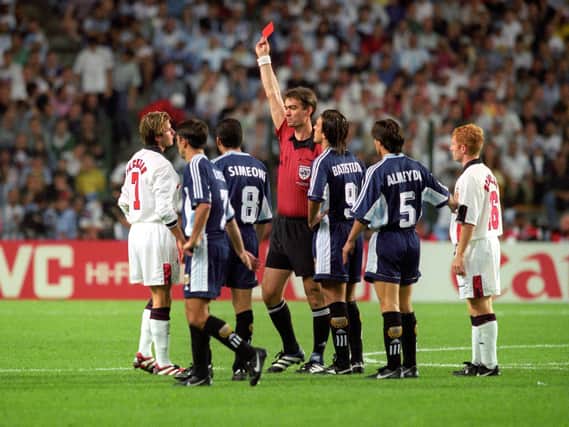 England's David Beckham (L) is given the red card by Danish referee Kim Milton Nielsen, after a foul on Argentina's Diego Simeone during their France '98 World Cup second round match