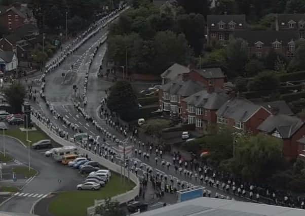 Aerial image of the route to Milltown lined with black-and-white mourners