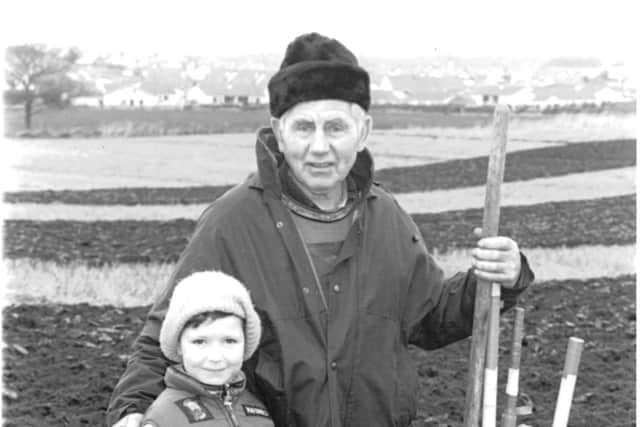 Six year old Jason McKay from Bushmills enjoying the annual ploughing competition of the Coleraine and District Ploughing Society at Limavady. He is pictured with his grandfather William McKay. Picture: Farming Life archives