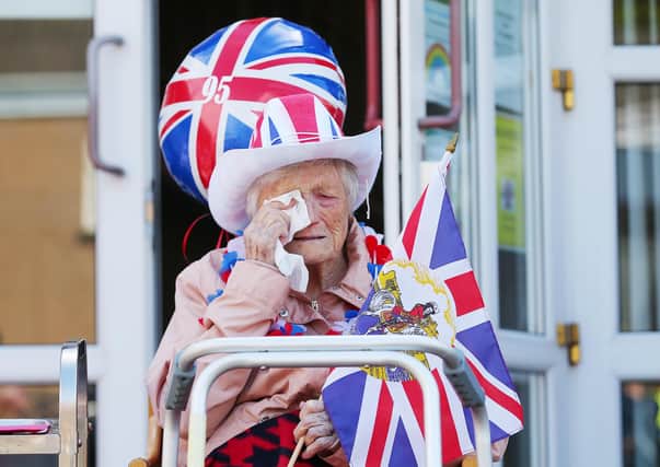 Ina McNeill, a resident at Giboney House Residential Home, wipes away tears yesterday after Braniel Loyal Flute Band paraded through Cregagh estate in east Belfast to present her with flowers on her 95th birthday