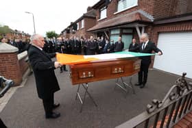 Sean Murray (left) and Gerry Kelly (right) place an Irish flag onto the coffin of senior Irish Republican and former leading IRA figure Bobby Storey ahead of his funeral in west Belfast. PA Photo. Picture date: Tuesday June 30, 2020. See PA story FUNERAL Storey Photo credit should read: Liam McBurney/PA Wire