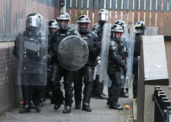 Police Service of Northern Ireland officers in riot gear carry out searches in the New Lodge area of Belfast. Niall Carson/PA Wire