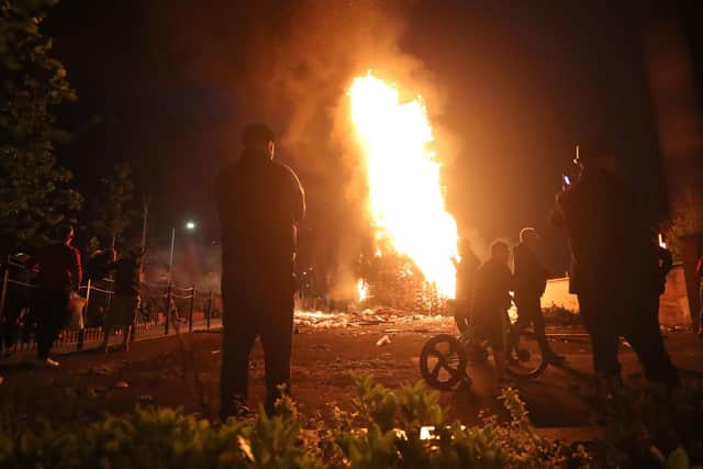 A bonfire is lit on Belfast's Lower Newtownards Road as smaller than usual bonfires were set to be lit at midnight. Photo : Niall Carson/PA Wire