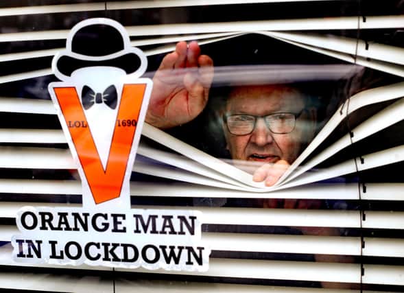 Orangeman Randy Davidson, who is isolating at home, poses with a sticker in his window to celebrate the 12th of July