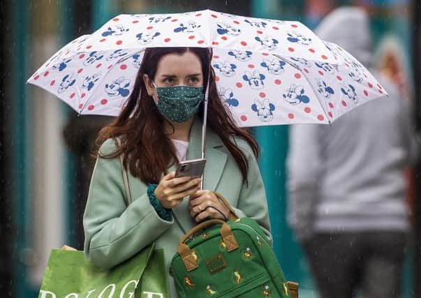 A woman in a face mask walks through Belfast city centre