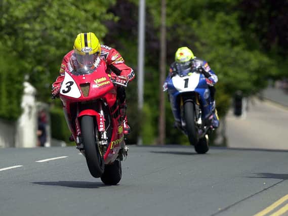 Joey Dunlop (Honda VTR SP-1) leads Ian Lougher in the Formula One race at the Isle of Man TT in 2000.
