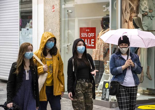 A group of young women walk through Belfast city centre's shopping district wearing face masks voluntarily on Tuesday, the day it was announced face masks will become mandatory in shops in England. Robin Swann has advised the same for Northern Ireland. Photo: Liam McBurney/PA Wire