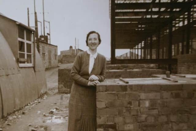 Medical Secretary Sarah Elliot. Corrugated Iron TB Clinic (left) and Erne Hospital Being Built Behind.