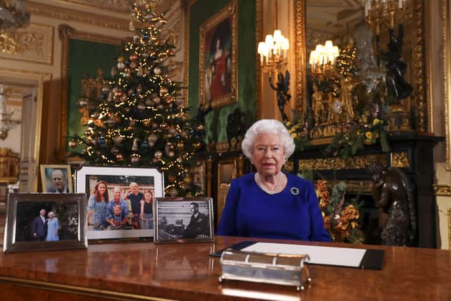 A picture released on December 24, 2019 shows Britain's Queen Elizabeth II posing for a photograph after she recorded her annual Christmas Day message, in Windsor Castle, west of London