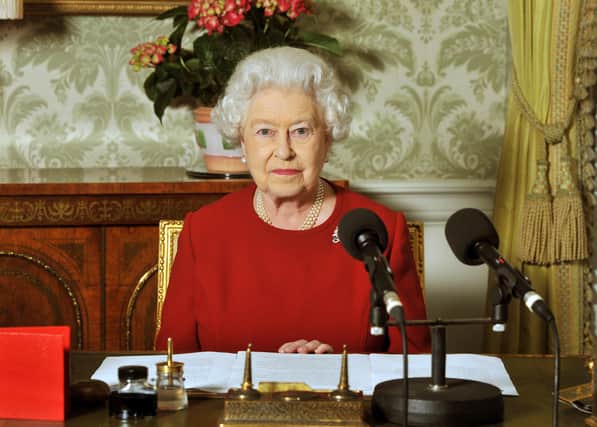 Queen Elizabeth II sits at her desk with microphones at Buckingham Palace after recording her Commonwealth Day address that is broadcast across the world on March 13, 2011 in London, England