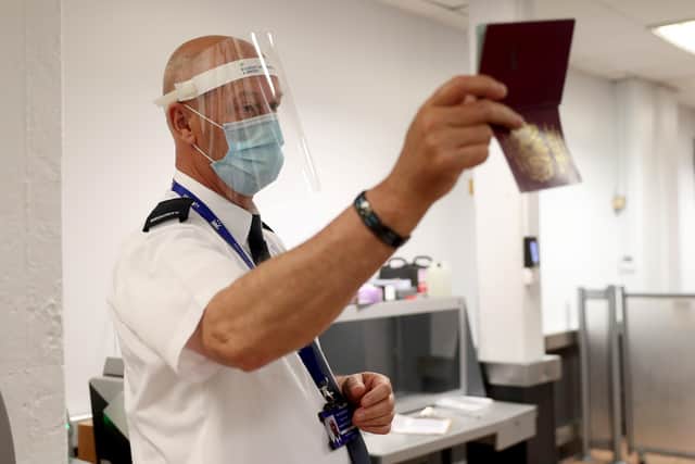 A security worker checks a passport at Belfast International Airport