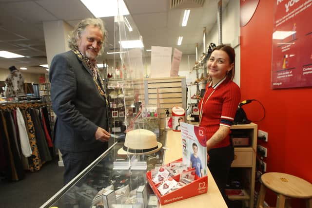BHF NI Belfast shop manager Jasmin Lawther serves President of Belfast Chamber Michael Stewart at the Fountain Street store