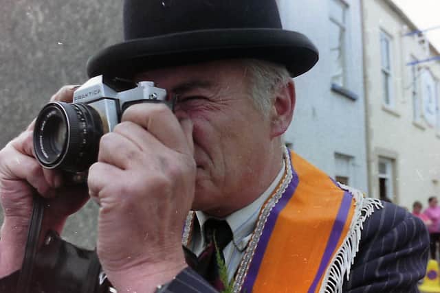 An Orangeman captures a photograph at the Twelfth in Donaghadee in 1996. An unpublished photograph from the News Letters archives