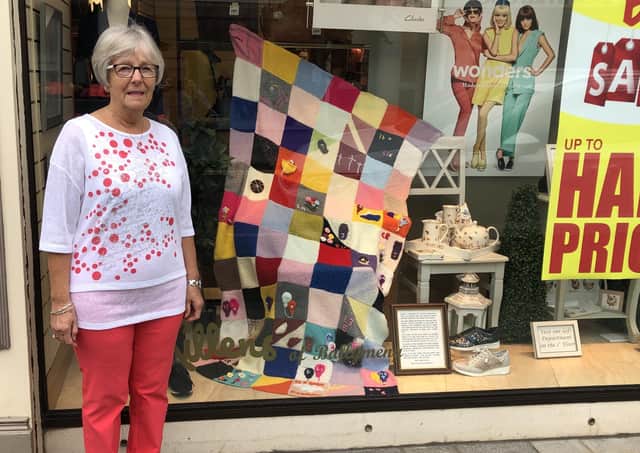 Edna Alexander outside McKillens department store in Ballymena where her knitted quilt is on display in the window
