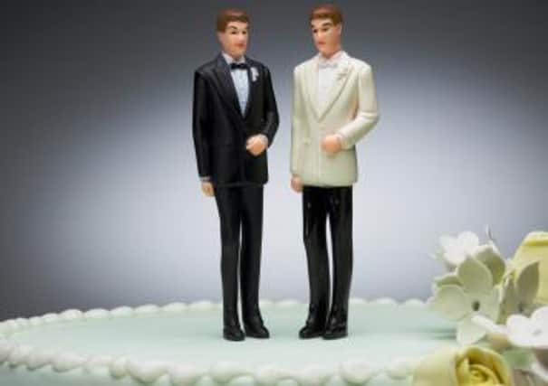 Two groom figurines on top of wedding cake