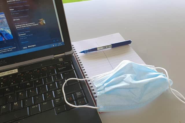 Laptop, notepad, pen and face mask