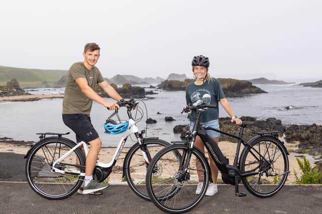 Cyclists Stephanie Penny and Mark Thompson take in the Causeway Coastal Route overlooking Whiterocks Beach with their newly hired eBikes