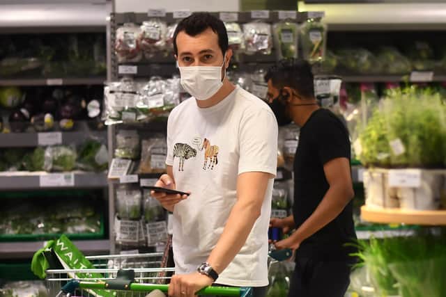 A shopper wearing a face mask in a supermarket.