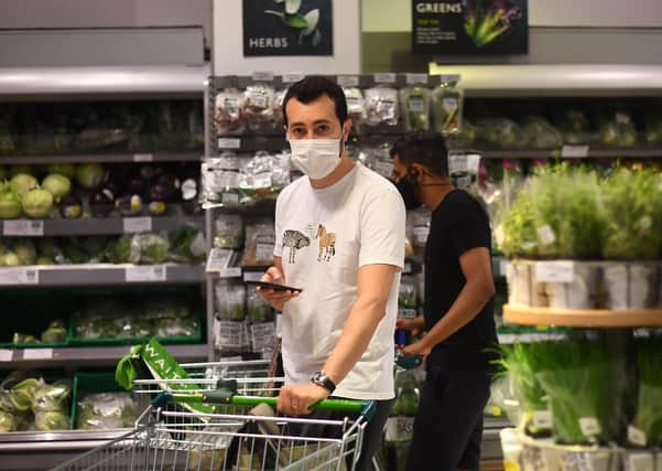 A shopper wearing a face mask in a supermarket in East London after face coverings became mandatory in shops in England. "Medical experts in various nations say compulsory masks are unwarranted," writes Patrick McGinnity