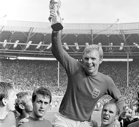 England's triumphant 1966 World Cup final captain Bobby Moore chaired by hat-trick hero Geoff Hurst (left) and Ray Wilson as he salutes the crowd