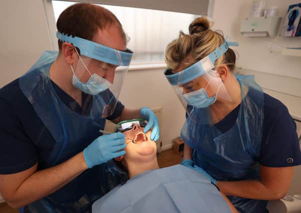 Dentist Dr. Alan Clarke and Dental Nurse Lynsey Galaway (right) wearing PPE with fellow dentist Dr. Danielle Magee
