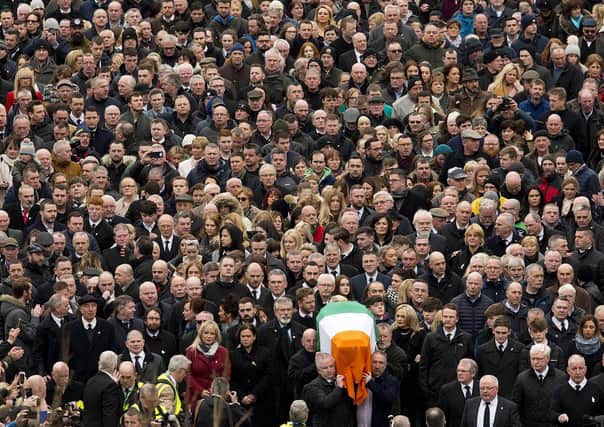 Crowds of mourners walk behind the coffin of the IRA leader Martin McGuinness during his funeral in Londonderry in 2017. The event got international attention