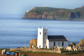 Digging potatoes near Ballintoy Parish Church in August 2011 with Bull Point on Rathlin Island as a backdrop as viewed from the McHenry farm. Picture: Kevin McAuley