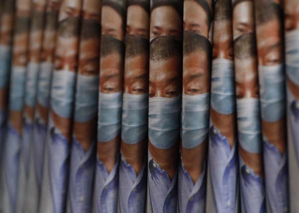 Copies of Apple Daily newspaper with front pages featuring Hong Kong media tycoon Jimmy Lai, are displayed for sale at a newsstand in Hong Kong, Tuesday, Aug. 11, 2020. Hong Kong police have arrested Lai and raided the publisher's headquarters, broadening their enforcement of a new security law (AP Photo/Kin Cheung)