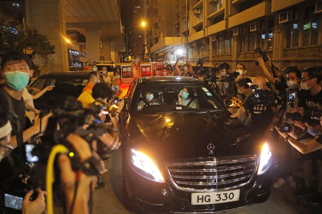 Hong Kong media tycoon and newspaper founder Jimmy Lai, front seat at right, leaves a police station after being bailed out in Hong Kong, Wednesday, Aug. 12, 2020. (AP Photo/Kin Cheung)