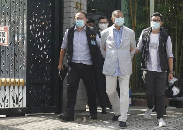 Media tycoon Jimmy Lai, centre, who founded local newspaper Apple Daily, is arrested by police at his home in Hong Kong, on Monday. He was detained on suspicion of collusion with foreign powers, in the highest-profile use yet of the new national security law Beijing imposed on the city after protests last year (AP Photo)