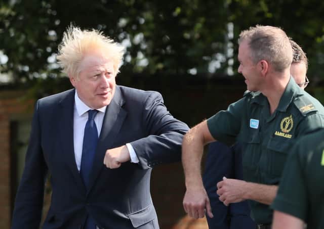 Prime Minister Boris Johnson elbow bumps a paramedic at the Northern Ireland Ambulance Service HQ during a photo op on Thursday