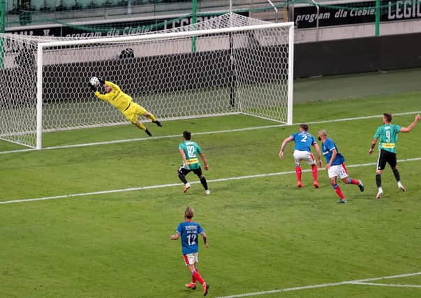 infield's Chris Johns makes a great save from Legia's Thomas Pekhart (no 9) in Warsaw.